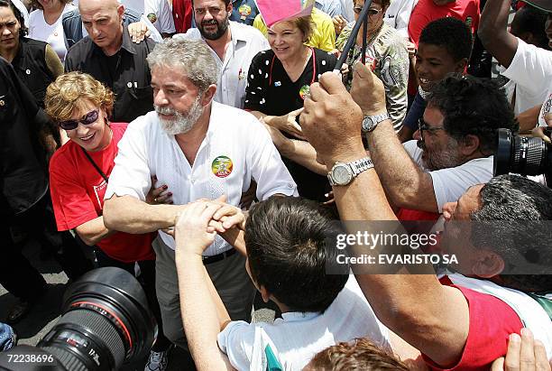 Brazilian President and re-election candidate Luiz Inacio Lula da Silva and his wife Marisa Leticia greet supporters during a campaign rally in Sao...