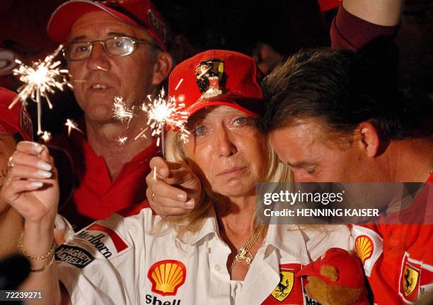 Supporters of German Ferrari driver Michael Schumacher light caldles as they watch on TV his last race, the Brazilian Formula One Grand Prix at the...