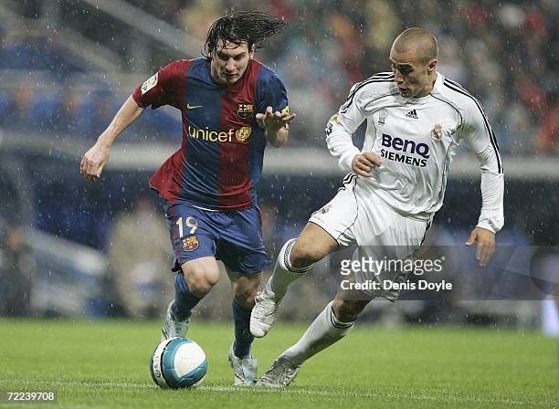Fabio Cannavaro of Real Madrid tackles Lionel Messi of Barcelona during the Primera Liga match between Real Madrid and Barcelona at the Santiago...