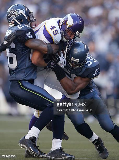 Tight end Richard Owens of the Minnesota Vikings is tackled by Ken Hamlin and Julian Peterson of the Seattle Seahawks at Qwest Field on October 22,...