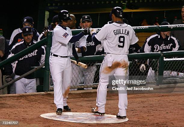 Carlos Guillen of the Detroit Tigers celebrates with Ramon Santiago after scoring in the fifth inning on an RBI single by Sean Casey against the St....