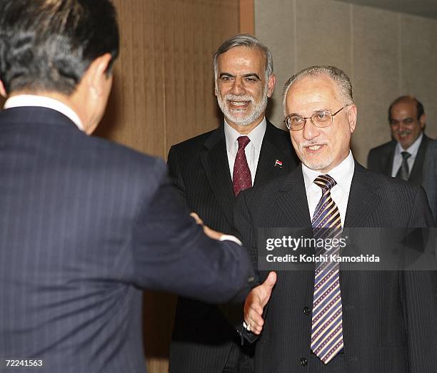 Iraqi oil minister Hussain al-Shahristani shakes hands with Japanese Foreign Minister Taro Aso at the Japanese Ministry of Foreign Affairs on October...