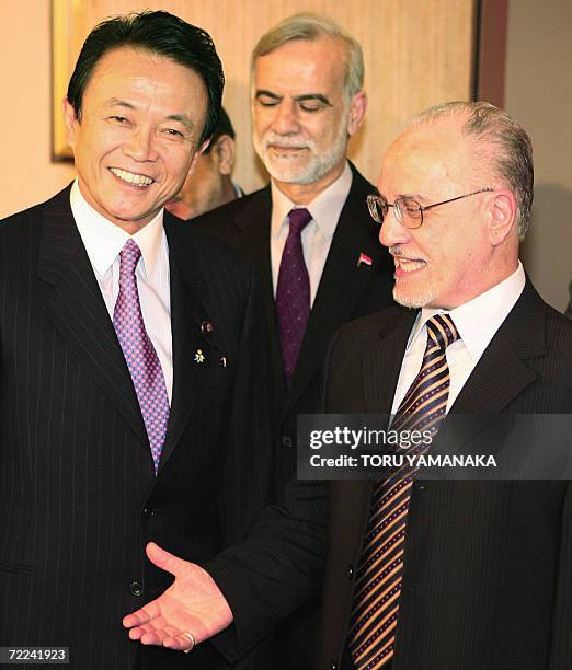 Iraqi Oil Minister Husayn al-Sharistani smiles with Japanese Foreign Minister Taro Aso while Iraqi Ambassador to Japan Ghanim Alwan al-Jumaily looks...