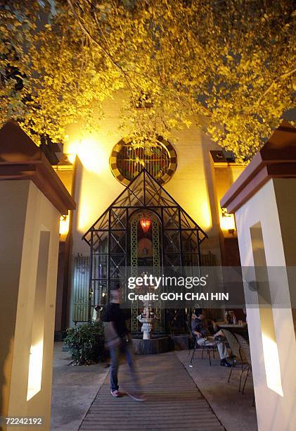Chinese waitress waits at the entrance to the God's Music bar, a former Catholic Cathedral in an area that used to be the French concession in early...