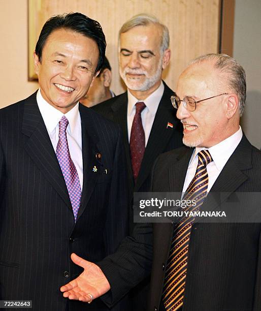 Iraqi Oil Minister Husayn al-Sharistani shares a smile with Japanese Foreign Minister Taro Aso while Iraqi Ambassador to Japan Ghanim Alwan...