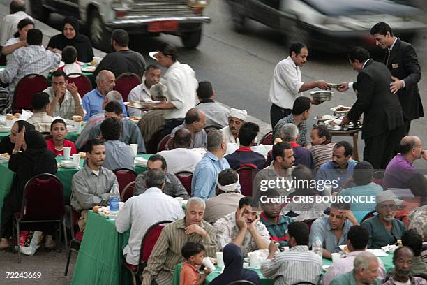 Needy Egyptians sitting at a makeshift dinning hall prepare to break their fast with Iftar -a meal traditionally shared with family and friends-...