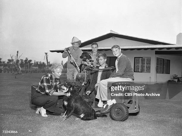 American comic film actor Harpo Marx poses with his wife actress Susan Fleming and their three adopted sons, Bill, Alex, and Jimmy, around a large...