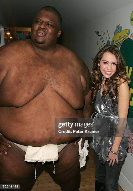 Sumo Wrestler Manny Yarbrough poses with Actress Miley Cyrus as she promotes her Walt Disney Records release of the soundtrack from her TV series...