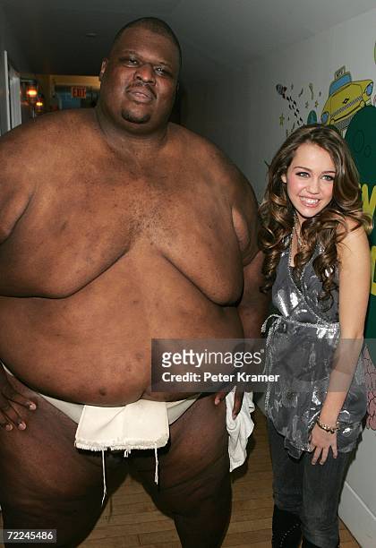 Sumo Wrestler Manny Yarbrough poses with Actress Miley Cyrus as she promotes her Walt Disney Records release of the soundtrack from her TV series...