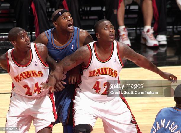 Marvin Williams of the Atlanta Hawks grabs the arm of Lorenzen Wright to block out Brendan Haywood of the Washington Wizards at Philips Arena on...