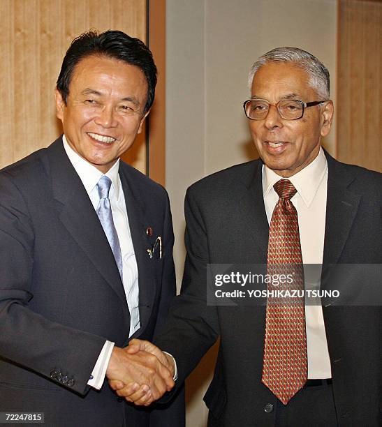 Visiting Indian National Security adviser M.K. Narayanan shakes hands with Japanese Foreign Minister Taro Aso prior to their talks in Tokyo, 24...