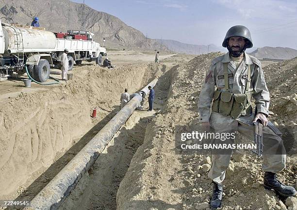 Pakistani paramilitary soldier stands guard near a damaged gas pipeline after a blast at Dasht, some 40 kns from Quetta, 24 October 2006. Suspected...