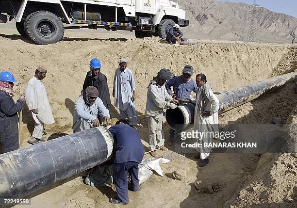 Pakistani gas company workers repair a damaged pipeline after a blast at Dasht, some 40kms from Quetta, 24 October 2006. Suspected tribal rebels blew...