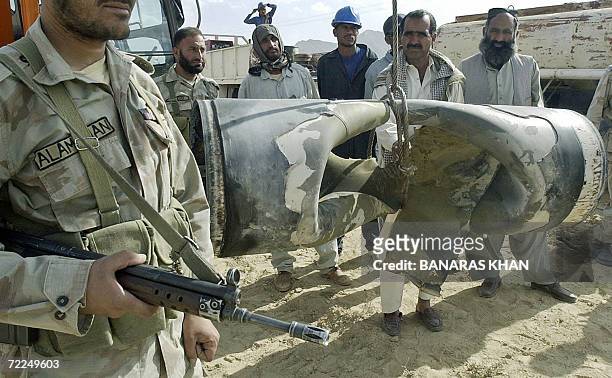 Pakistani paramilitary soldier and gas company workers stand next to a damaged pipeline after a blast at Dasht some 40kms from Quetta, 24 October...