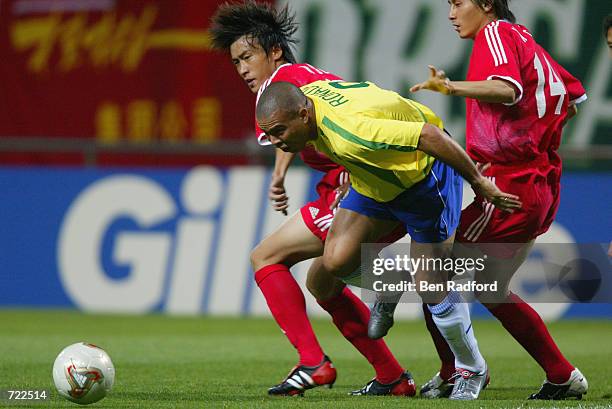 Ronaldo of Brazil takes the ball past Wei Du and Weifeng Li of China during the FIFA World Cup Finals 2002 Group C match played at the Seogwipo-Jeju...