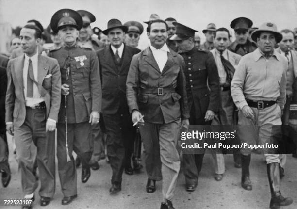 President of Cuba Fulgencio Batista pictured with various Cuban army officers after successfully crushing another coup attempt in the country,...