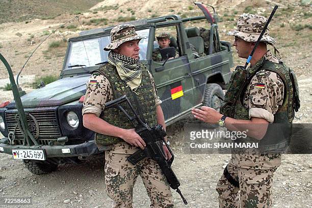 German troops from the International Security Assistance Force patrol the Butkhak district of southern Kabul where one of their comrades was killed...
