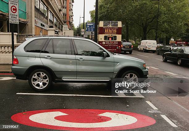 4x4 vehicle drives past a congestion charge sign painted on the road on October 25, 2006 in London, England. Gas-guzzling vehicles are being targeted...