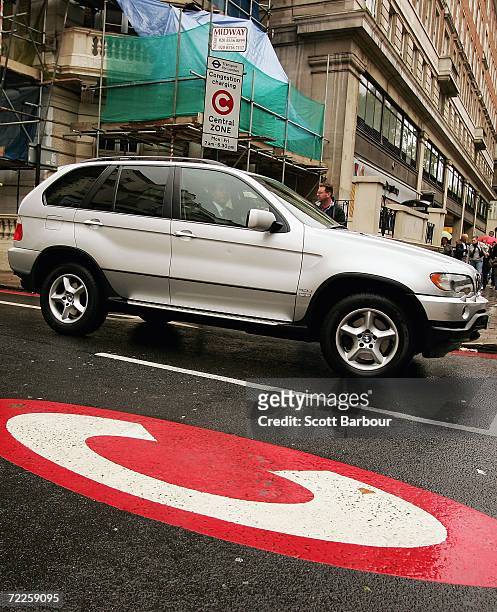 4x4 vehicle drives past a congestion charge sign painted on the road on October 25, 2006 in London, England. Gas-guzzling vehicles are being targeted...