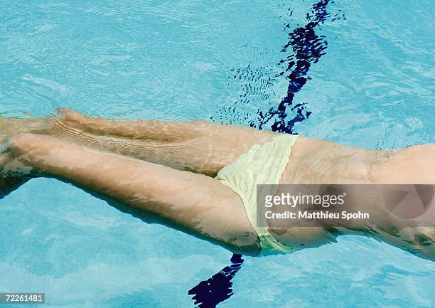 woman floating on back in pool, mid section - monokini stock pictures, royalty-free photos & images