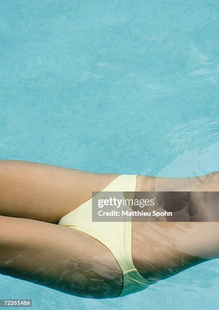 woman floating in pool, close-up of mid section - monokini stock pictures, royalty-free photos & images