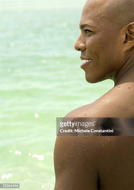 man smiling, profile, sea in background - hunky guy on beach stock pictures, royalty-free photos & images