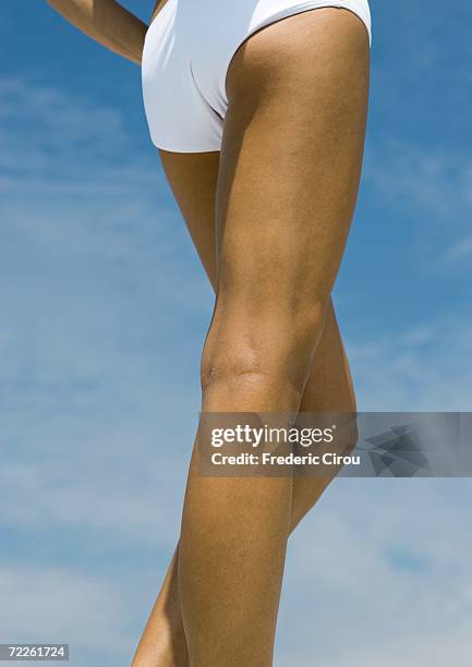 woman standing in sun, close-up of legs - monokini stock pictures, royalty-free photos & images