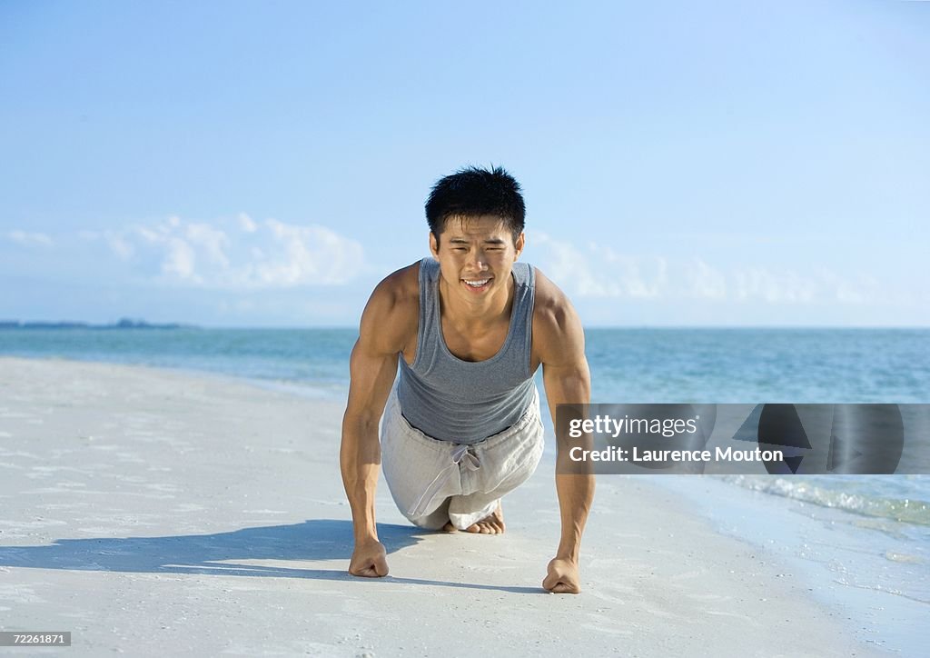 Man doing push-ups on beach