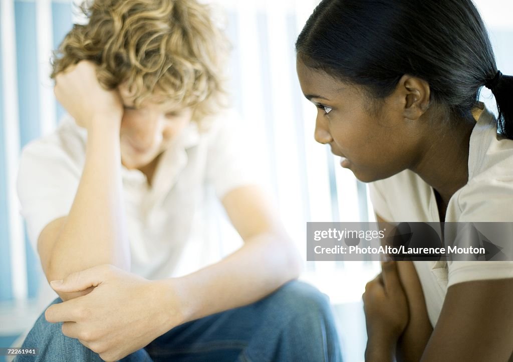 Teen boy and girl having serious conversation