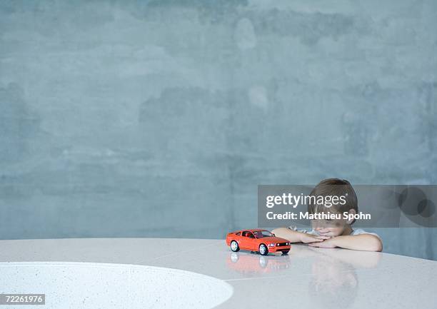 boy looking at toy car - boy with car stock-fotos und bilder