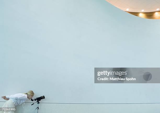 girl looking through telescope - bending over in skirt stock-fotos und bilder