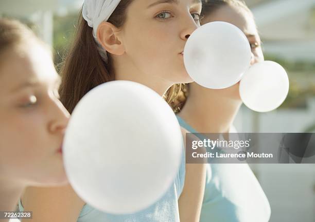 preteen girls blowing bubbles with chewing gum - chewinggum stockfoto's en -beelden