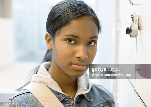 teen girl standing next to locker - black girl ponytail stock pictures, royalty-free photos & images