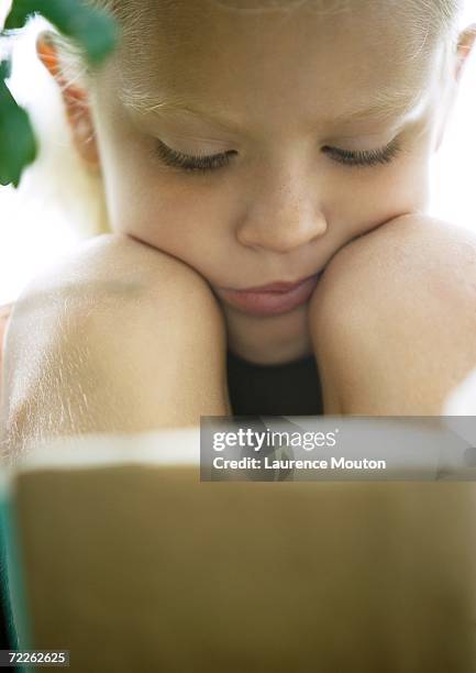 girl reading - curled up reading book stock pictures, royalty-free photos & images