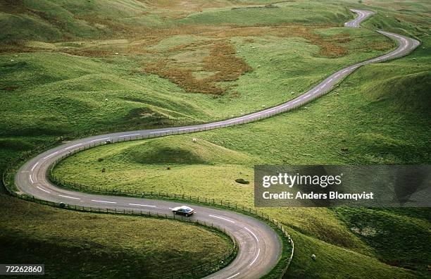 car travelling down snaking road through grazing land of the peak district, united kingdom - car view stock pictures, royalty-free photos & images