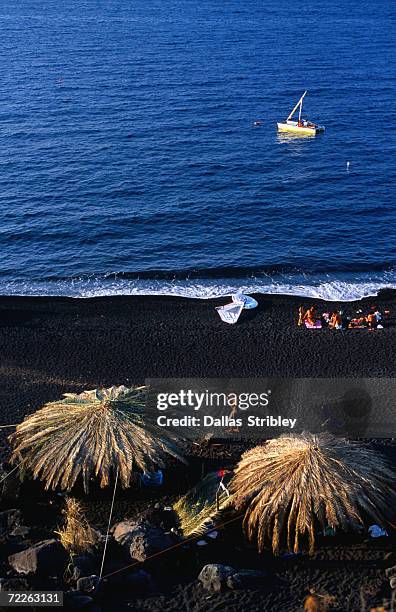 overhead of strolling and sunbaking on the black volcanic sands of piscita beach, piscita, italy - stromboli stock-fotos und bilder