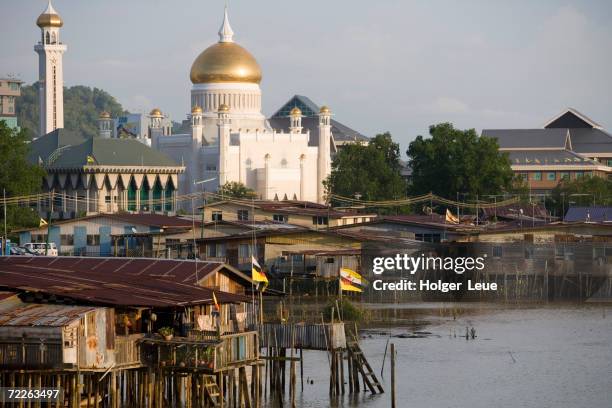 stilt houses on brunei river, omar ali saifuddien mosque in distance, bandar seri begawan, brunei darussalam, brunei - sultan omar ali saifuddin mosque stock-fotos und bilder