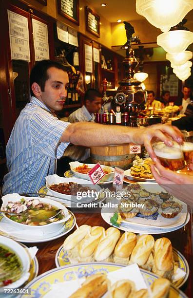 pinxtos (tapas) on counter of busy ormazabal taberna bar, san sebastian, spain - spain san sebastian imagens e fotografias de stock