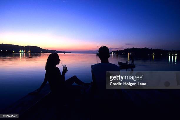 silhouetted couple at dusk at huntress marina, port antonio, jamaica - ポートアントニオ ストックフォトと画像