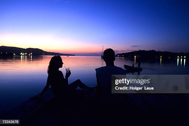 silhouetted couple at dusk at huntress marina, port antonio, jamaica - port antonio jamaica stockfoto's en -beelden