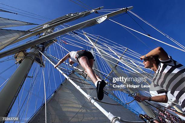 young woman on mastclimbing aboard star flyer, andaman sea, thailand - star flyer stock pictures, royalty-free photos & images