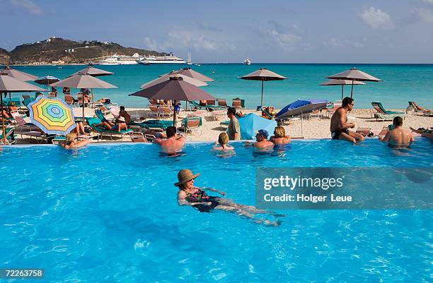 people swimming and sunbathing at great bay beach hotel pool, philipsburg, netherlands antilles - guadeloupe beach stockfoto's en -beelden