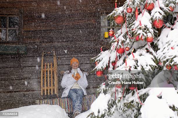 young woman looking at christmas tree, smiling - christmas window stock pictures, royalty-free photos & images