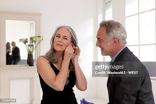 man looking at women wearing gifted earrings, smiling - ärmelloses kleid stock-fotos und bilder