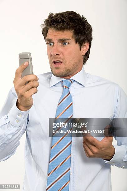young businessman looking at mobile phone, close-up - ragazzo disperato telefono foto e immagini stock