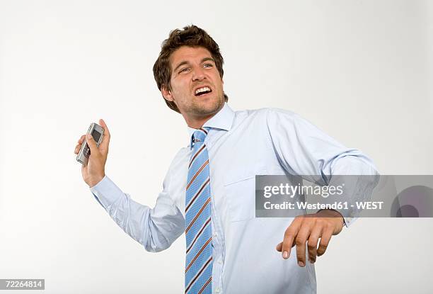 young businessman throwing mobile phone, close-up - throwing phone stock pictures, royalty-free photos & images