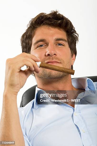 young man holding cigar, close-up, portrait - cigar stock-fotos und bilder