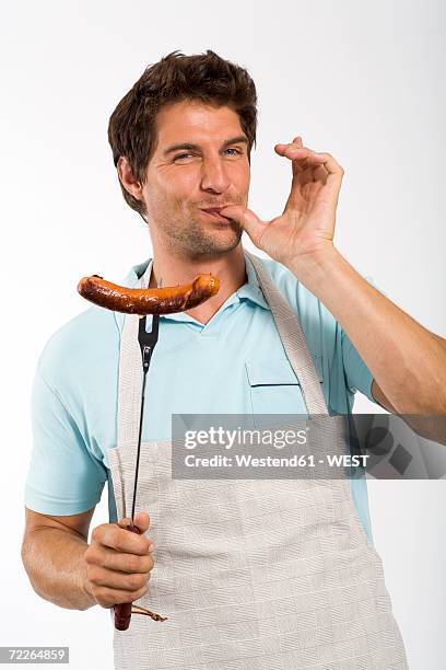 young man with grilled sausage on fork, portrait - man made object bildbanksfoton och bilder