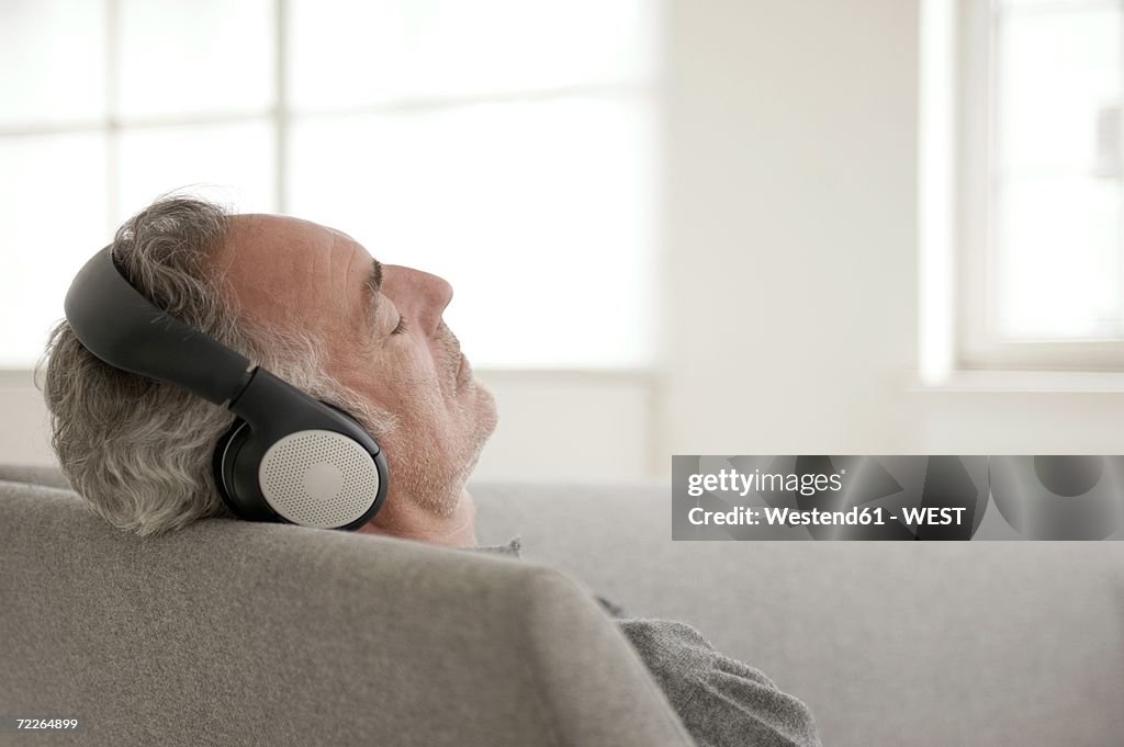 Mature man wearing headphones, eyes closed