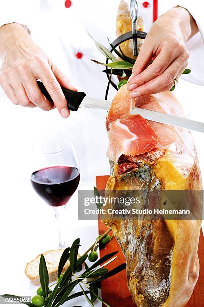 chef cutting serrano ham, close-up, mid section - wine glass finger food stock-fotos und bilder